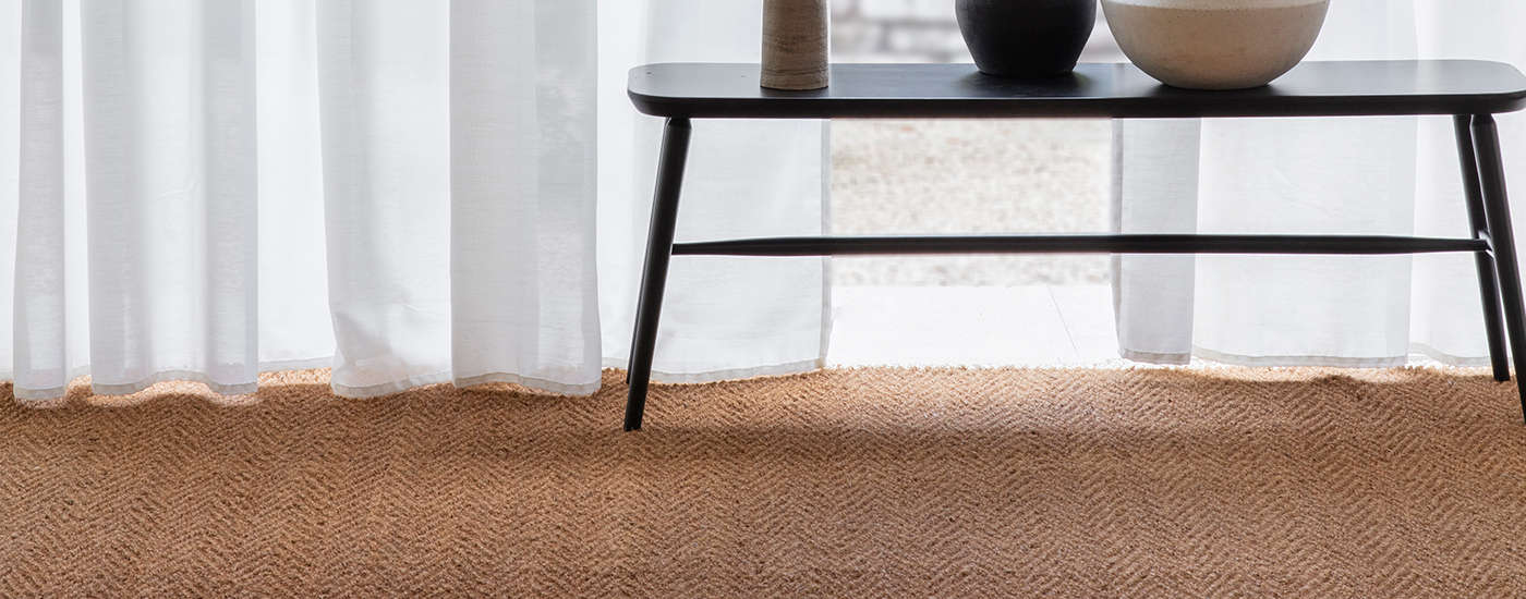 room with coffee table stood on natural coir herring bone carpet